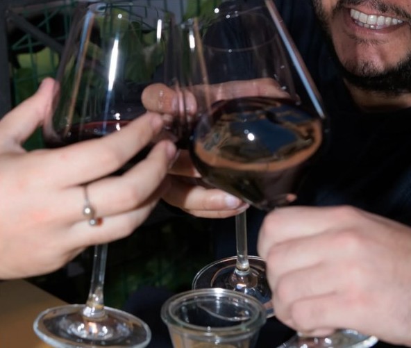 Brindisi con due calici di rosso